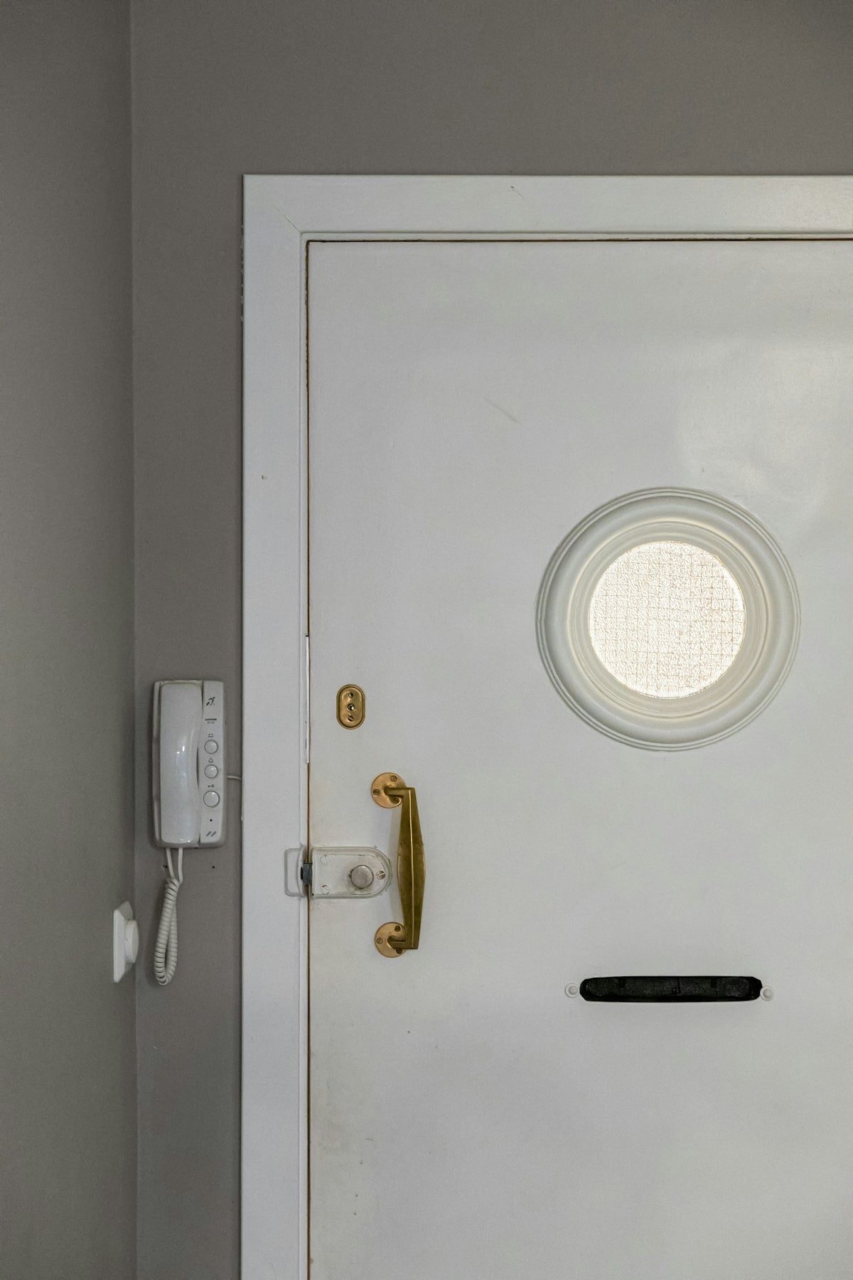 A white door with a round window in a room